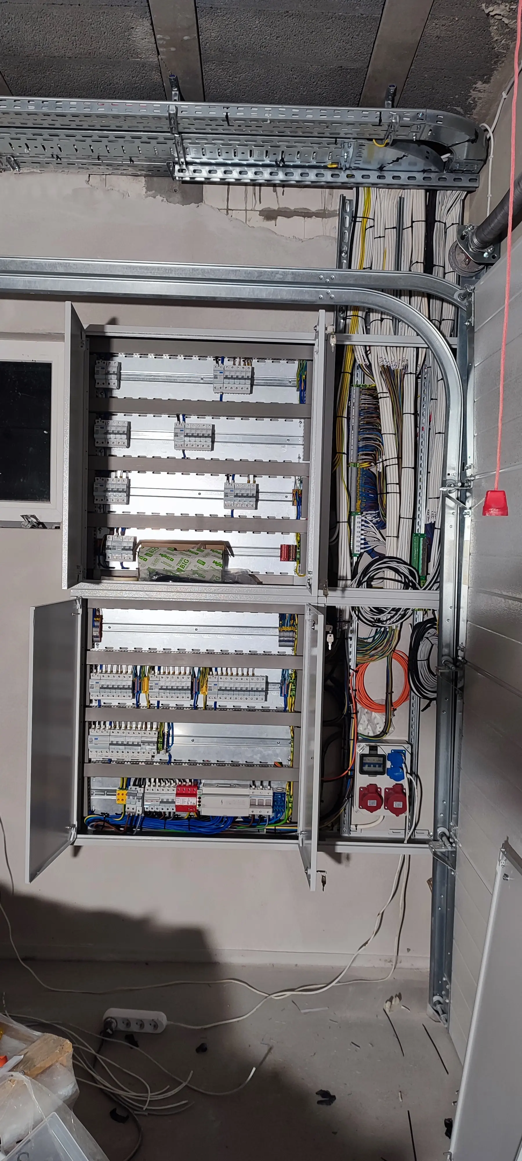 Technik opisujący przewody w szafie elektrycznej